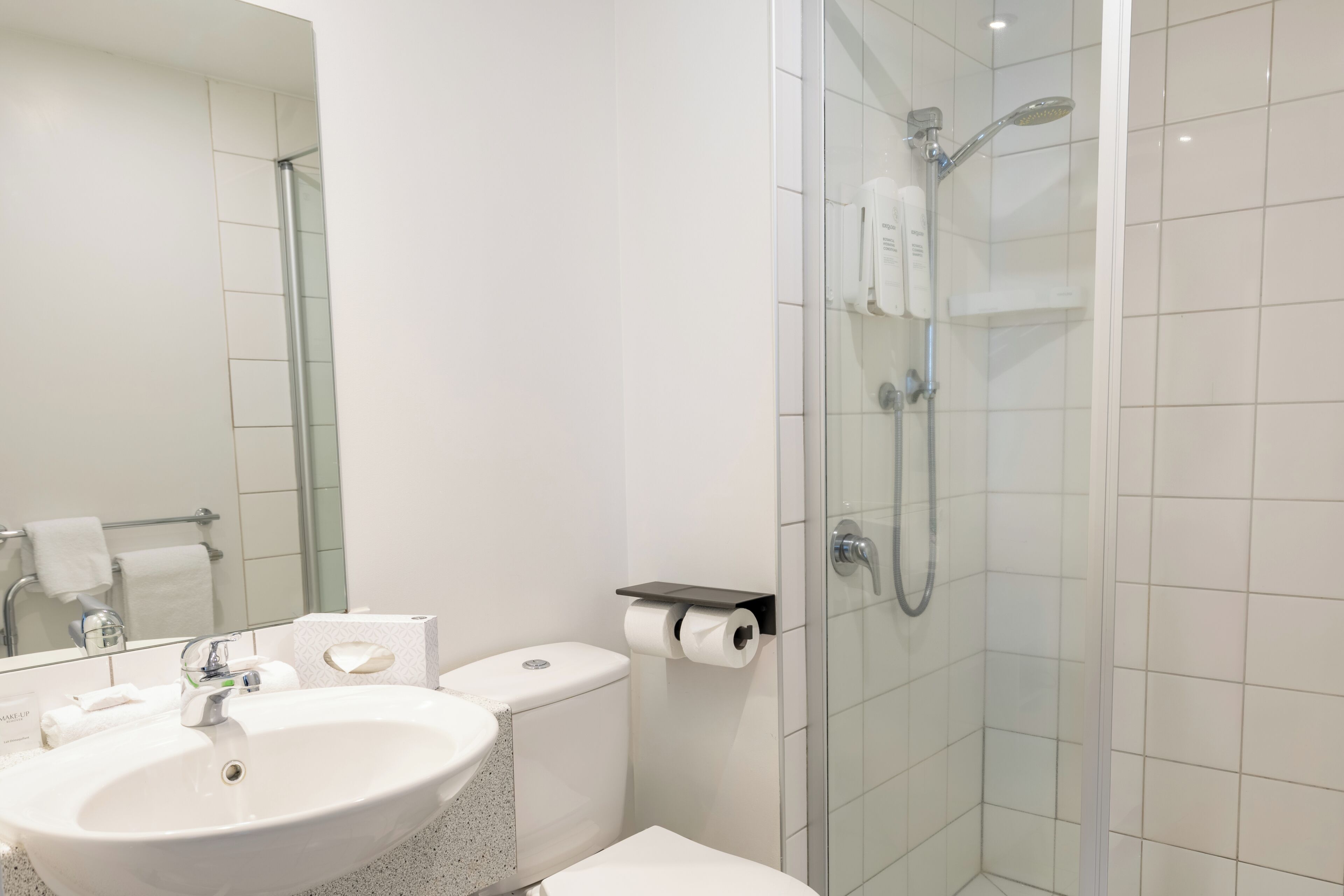 A modern bathroom with a sink, toilet, and glass-enclosed shower.