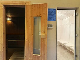 A wooden door leading to a sauna area with a control panel and a blue informational sign.