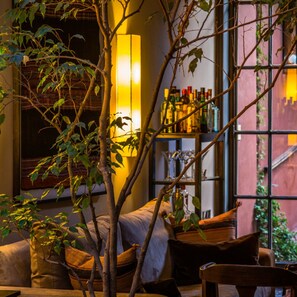 A cozy room with a large window, a bookshelf with various items, and a comfortable seating area with cushions. - Be Jardin Escondido by Coppola (Buenos Aires)