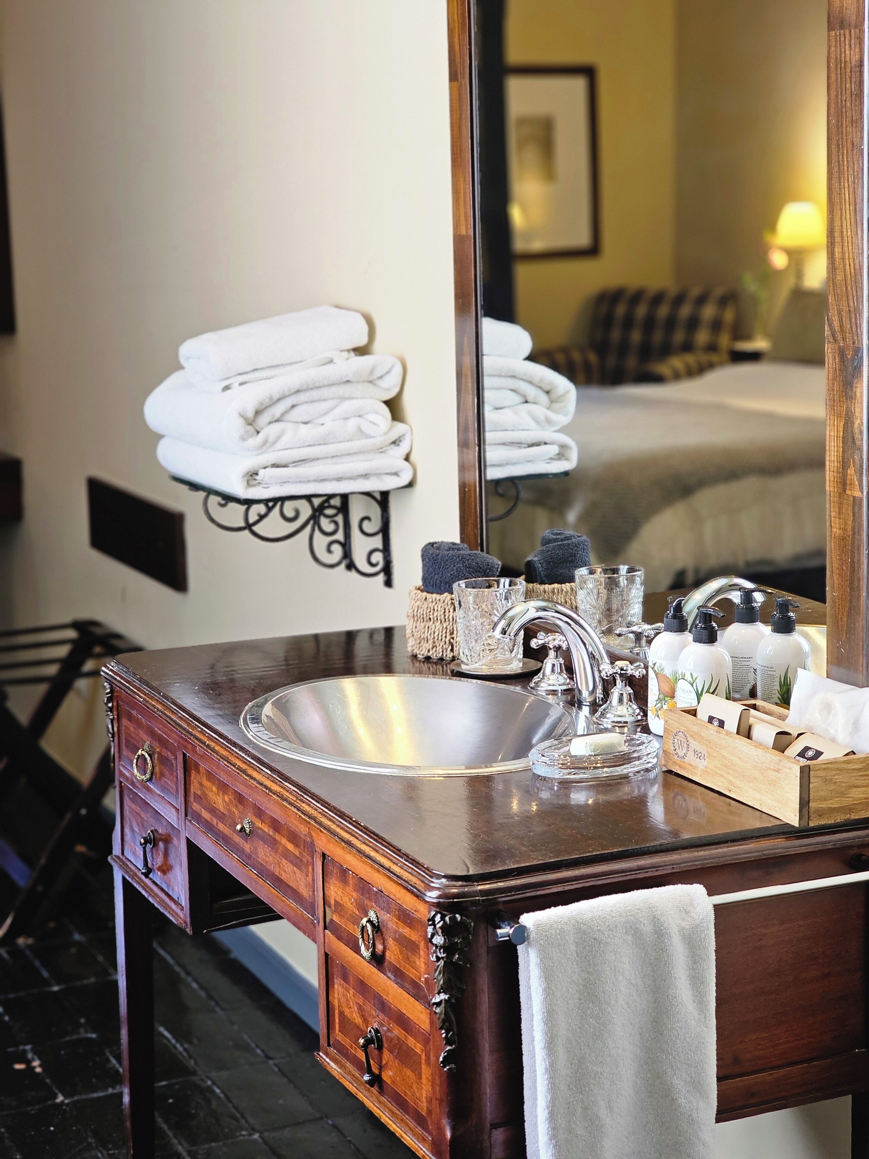 A wooden vanity with a large mirror, a sink, and a towel rack.