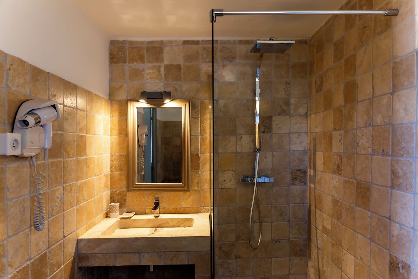 A bathroom with a sink, mirror, and shower.