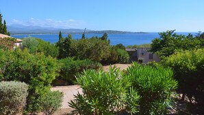 Un paysage côtier offrant une vue dégagée sur la mer et les montagnes lointaines.