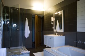 Suite junior, en edificio anexo (250 m) | Baño | Ducha, cabezal de ducha tipo lluvia, secador de pelo y toallas