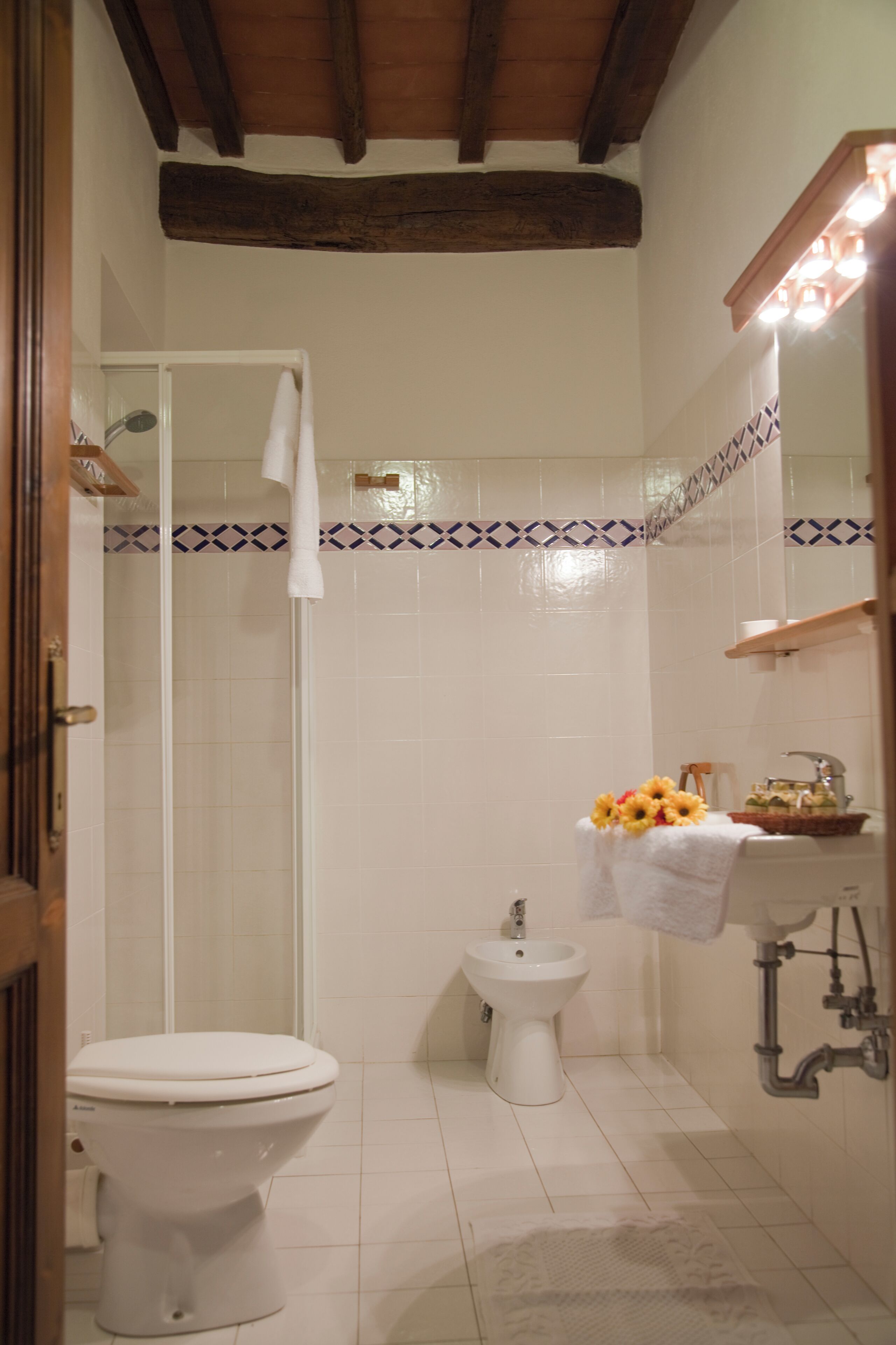 A bathroom with a toilet, bidet, and a sink with a mirror.