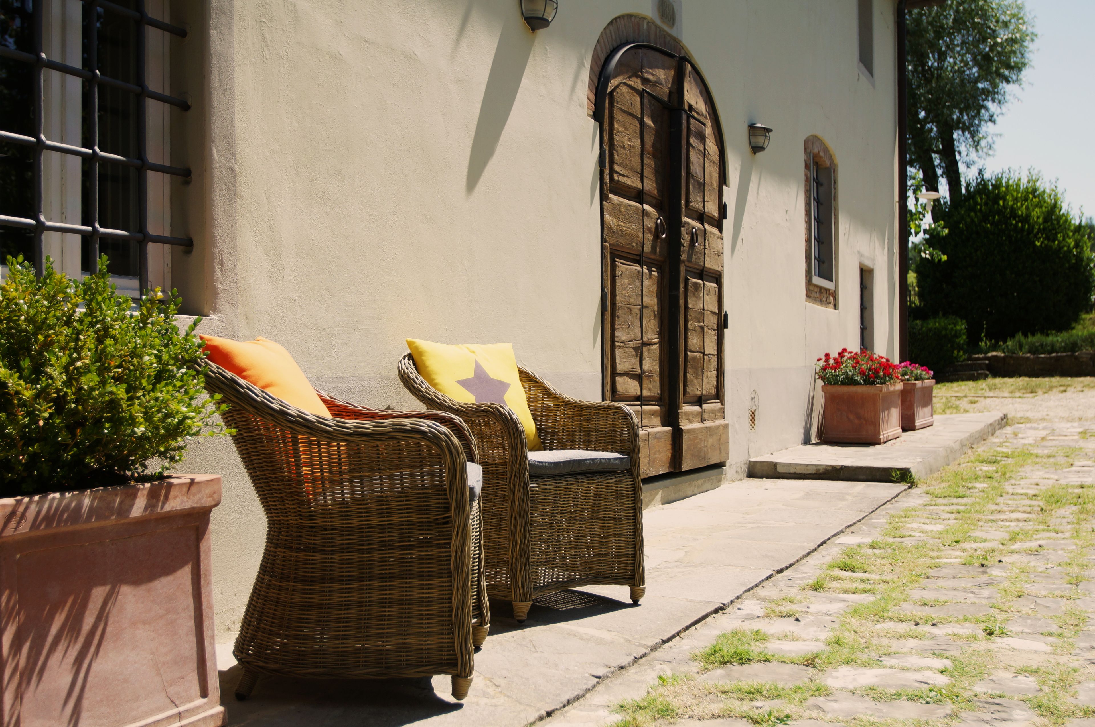 Un cortile con mobili in vimini e piante in vaso.