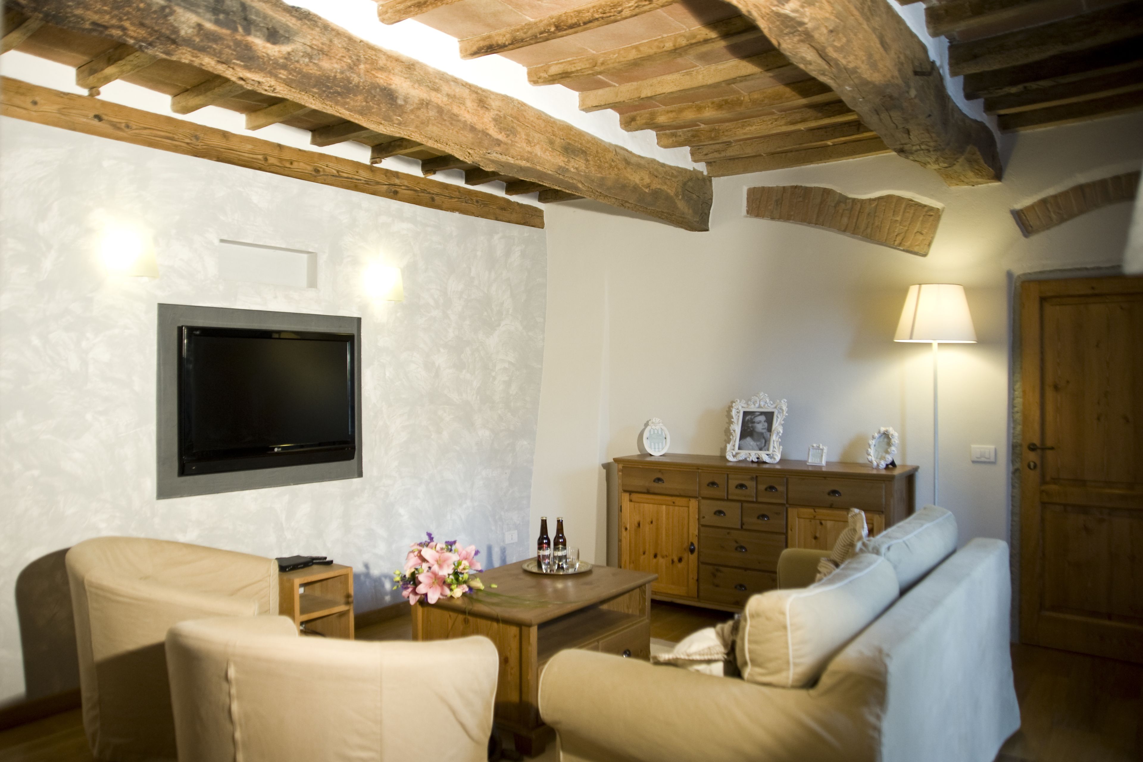 Un salon chaleureux avec un téléviseur à écran plat, des meubles en bois et un mur en pierre.