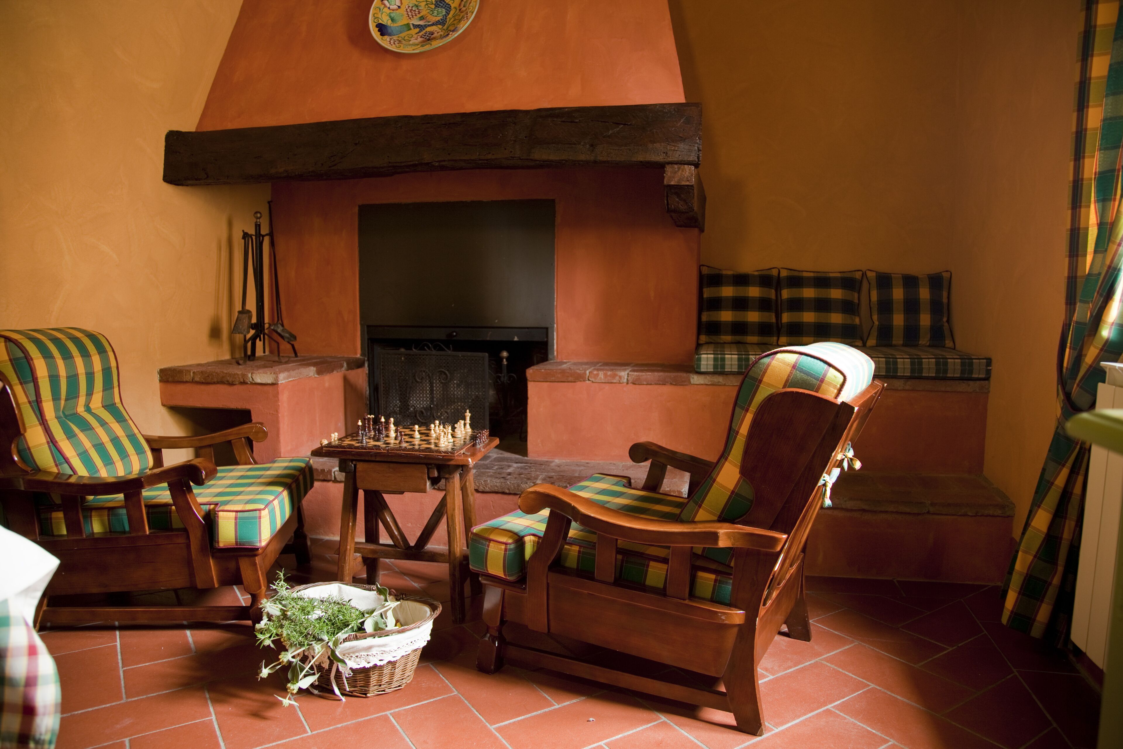 A cozy living room with a fireplace, wooden furniture, and a chessboard.