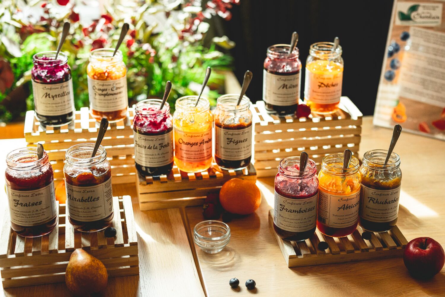 A wooden table with various jars of preserves and a small bowl.