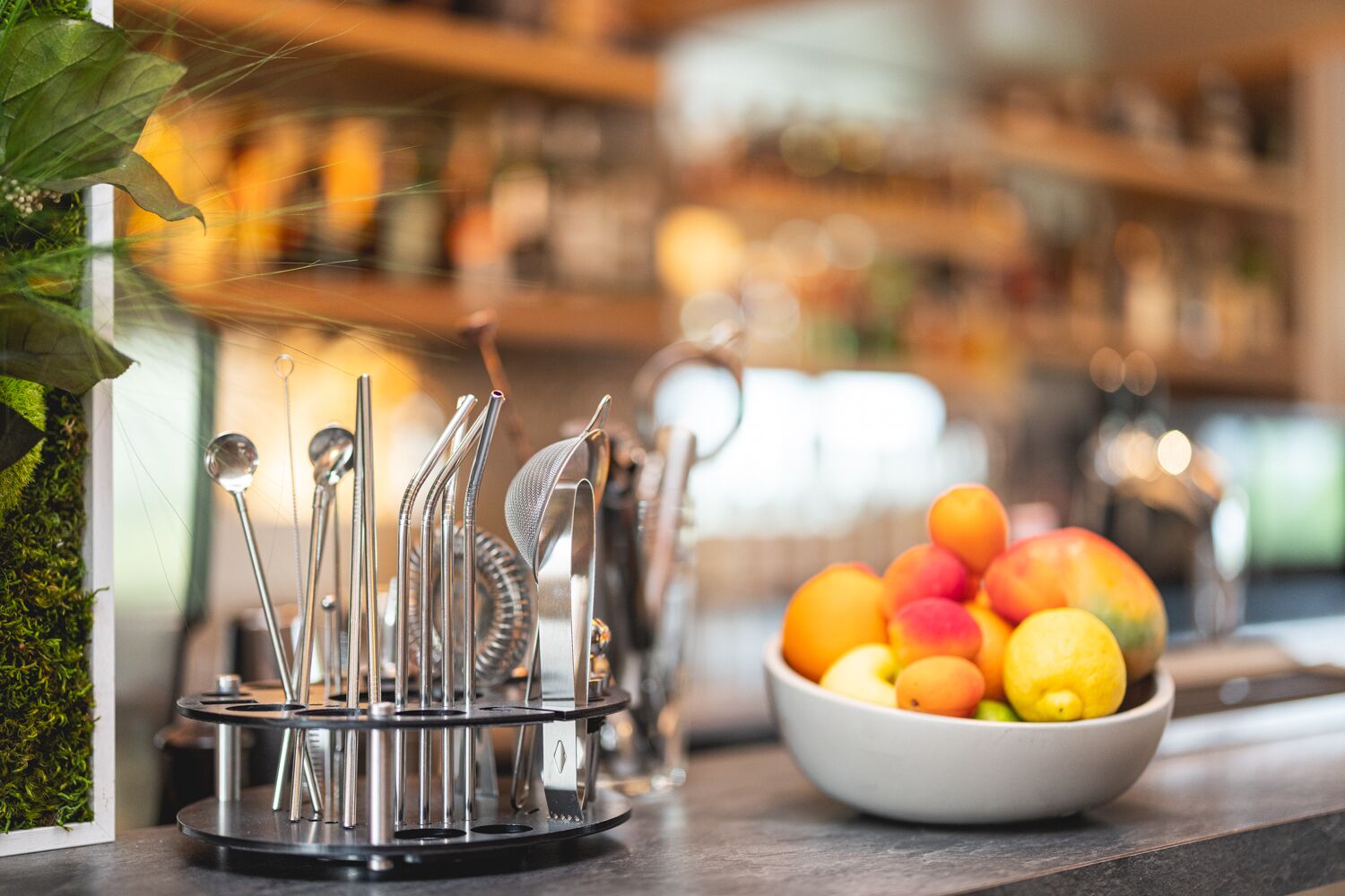 A kitchen counter with a fruit bowl and a utensil holder.