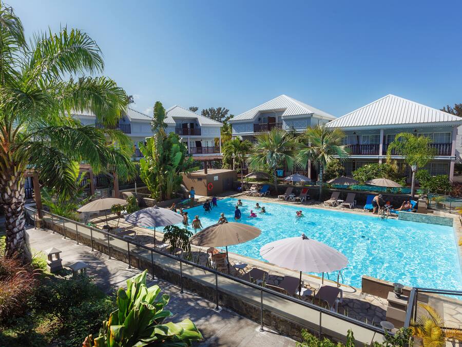 Een buitenzwembad, ligstoelen bij het zwembad