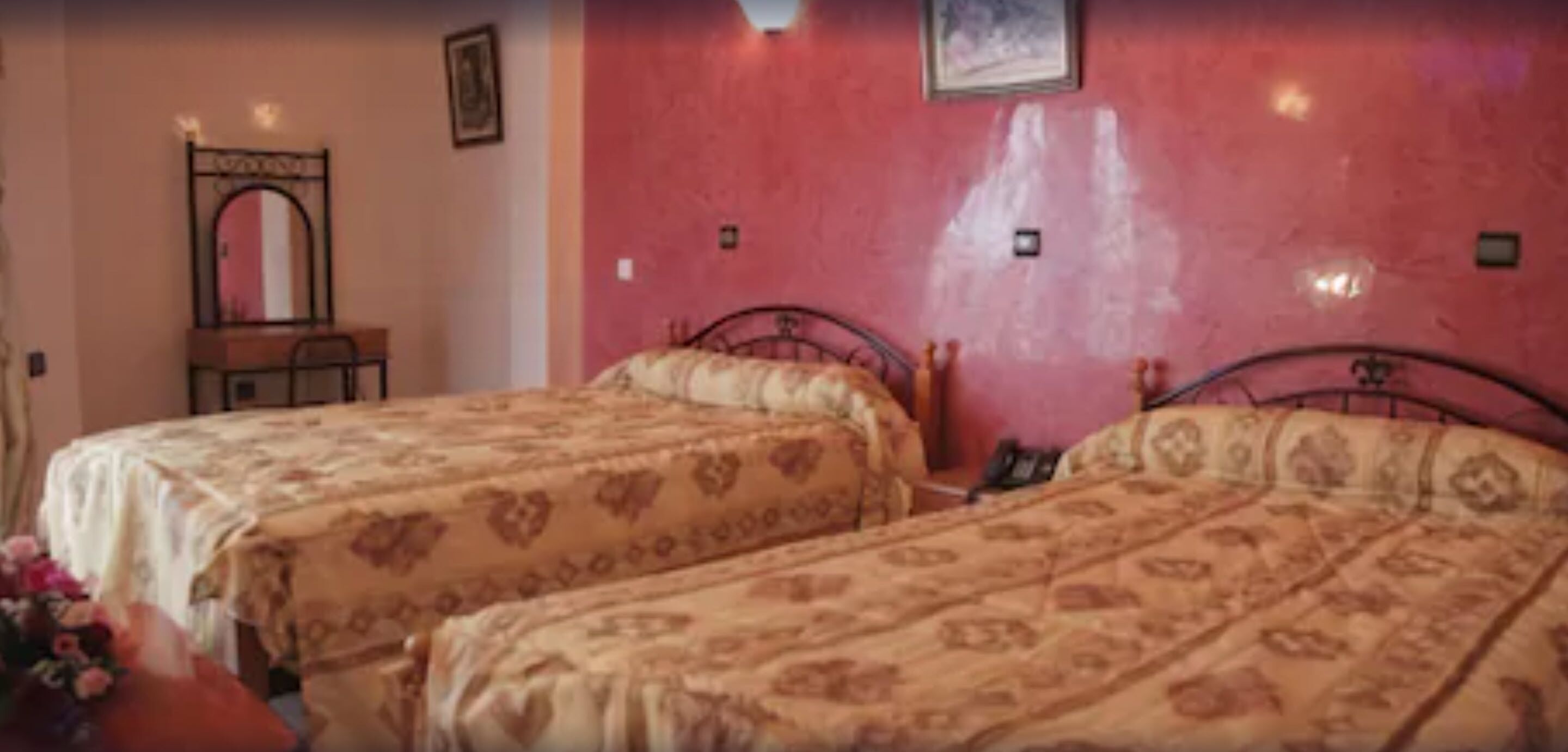 Un dormitorio con dos camas, un espejo y un aparador.