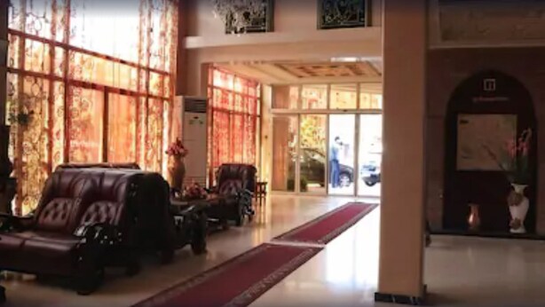 A spacious lobby with a red carpet, leather seating, and a large window with patterned curtains. - Hotel Alkabir (Marrakech)