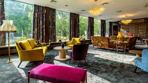 A modern hotel room with large windows, a dining area, and a variety of seating options. - tinyTwice Hotel Bonn (Bonn)
