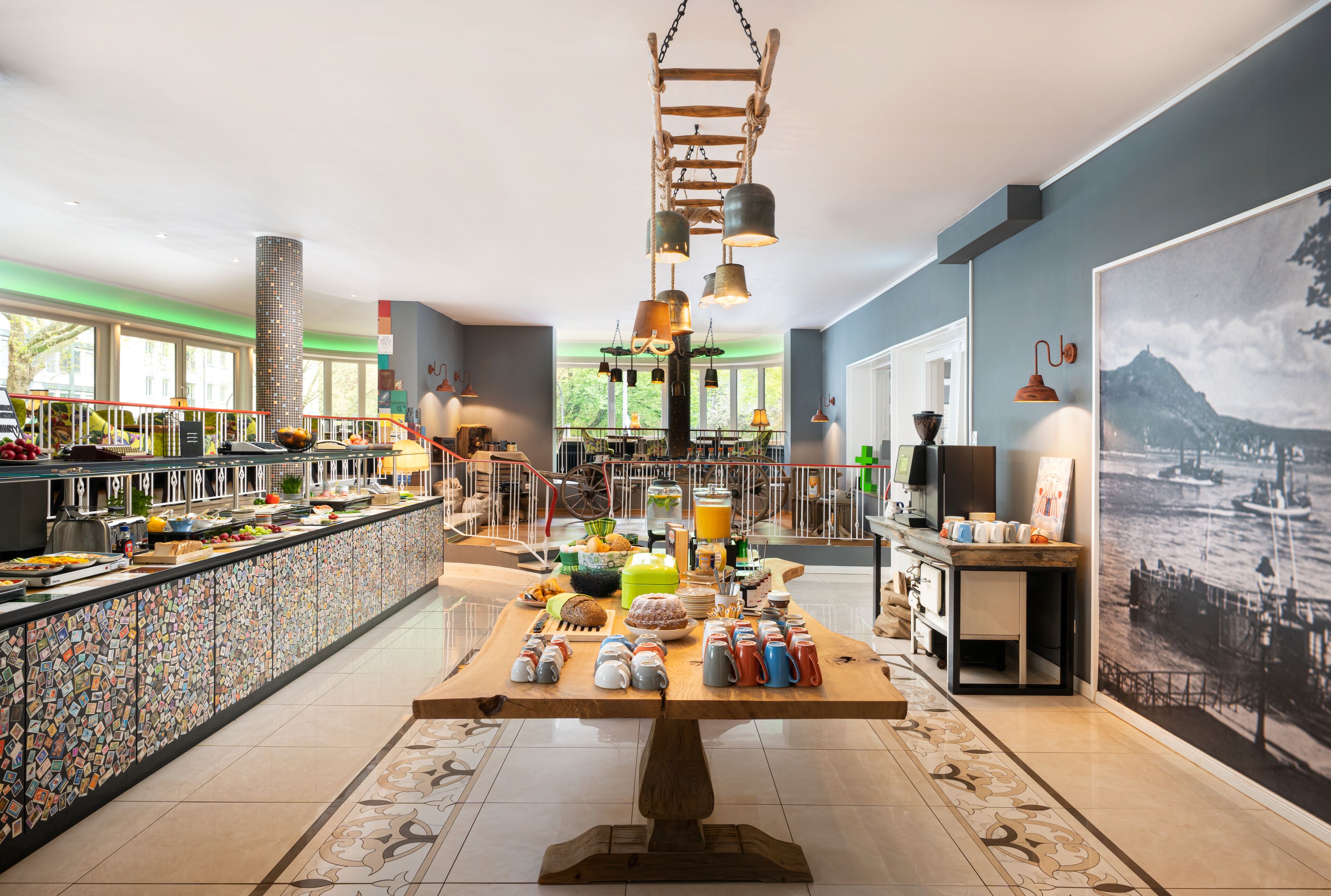 A breakfast buffet with a variety of food items and a large table with coffee mugs.