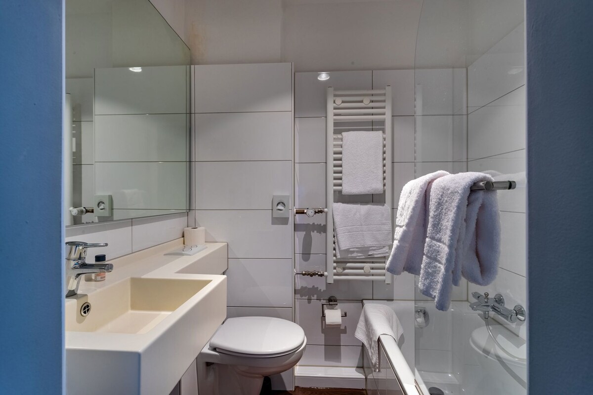 A modern bathroom with a toilet, sink, and bathtub.