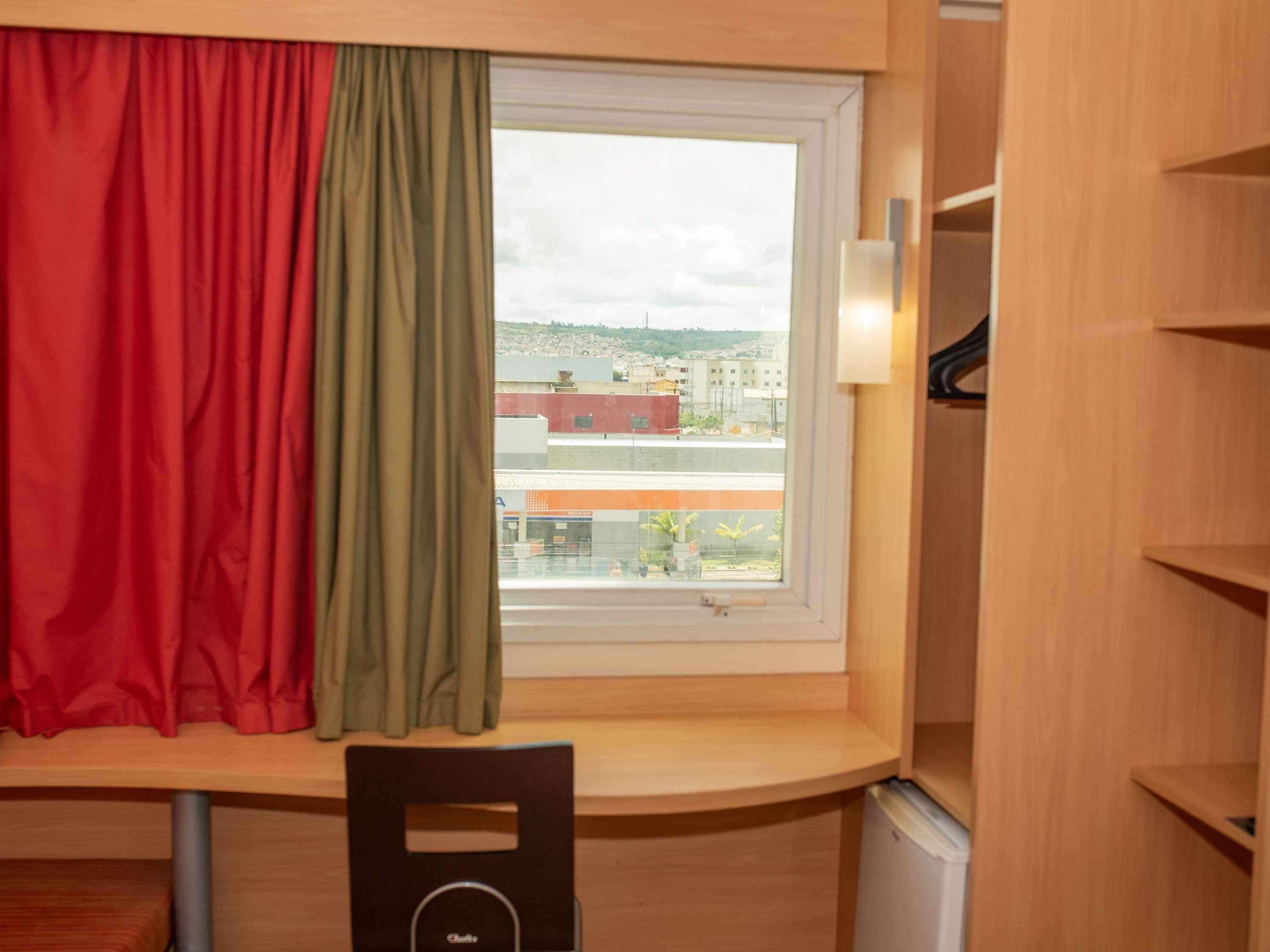 A room with a window, a chair, and a radiator.