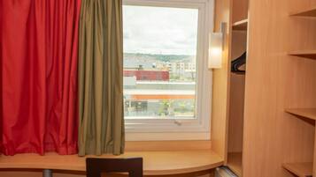 A room with a window, a chair, and a radiator.