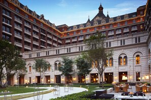 A large hotel with multiple balconies, a courtyard with outdoor seating, and a well-lit facade. - The Ritz-Carlton, Tianjin (Tianjin)