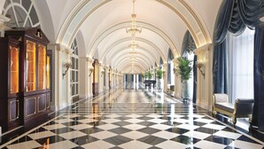 A grand hallway with a checkered floor, arched ceilings, and chandeliers. - The Ritz-Carlton, Tianjin (Tianjin)