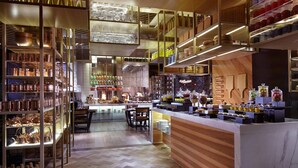 A modern interior with a bar area, shelves with glassware, and a wooden counter with food items. - The Ritz-Carlton, Tianjin (Tianjin)