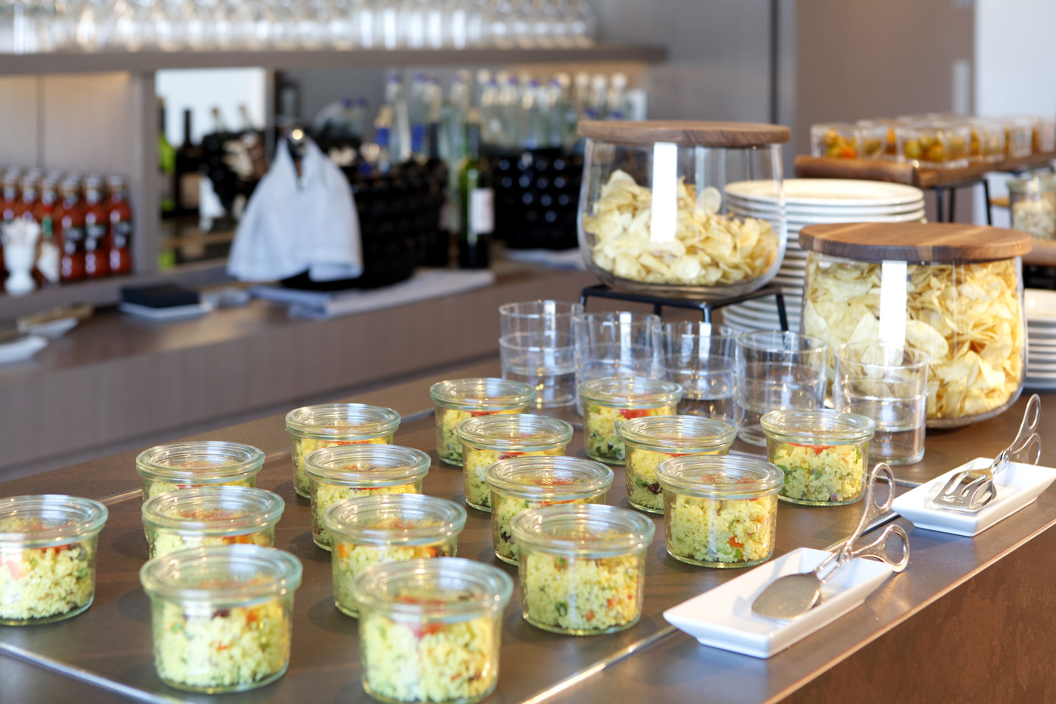 A buffet table with various food items and utensils.
