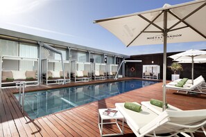 Piscina a l'aire lliure de temporada, para-sols i gandules 