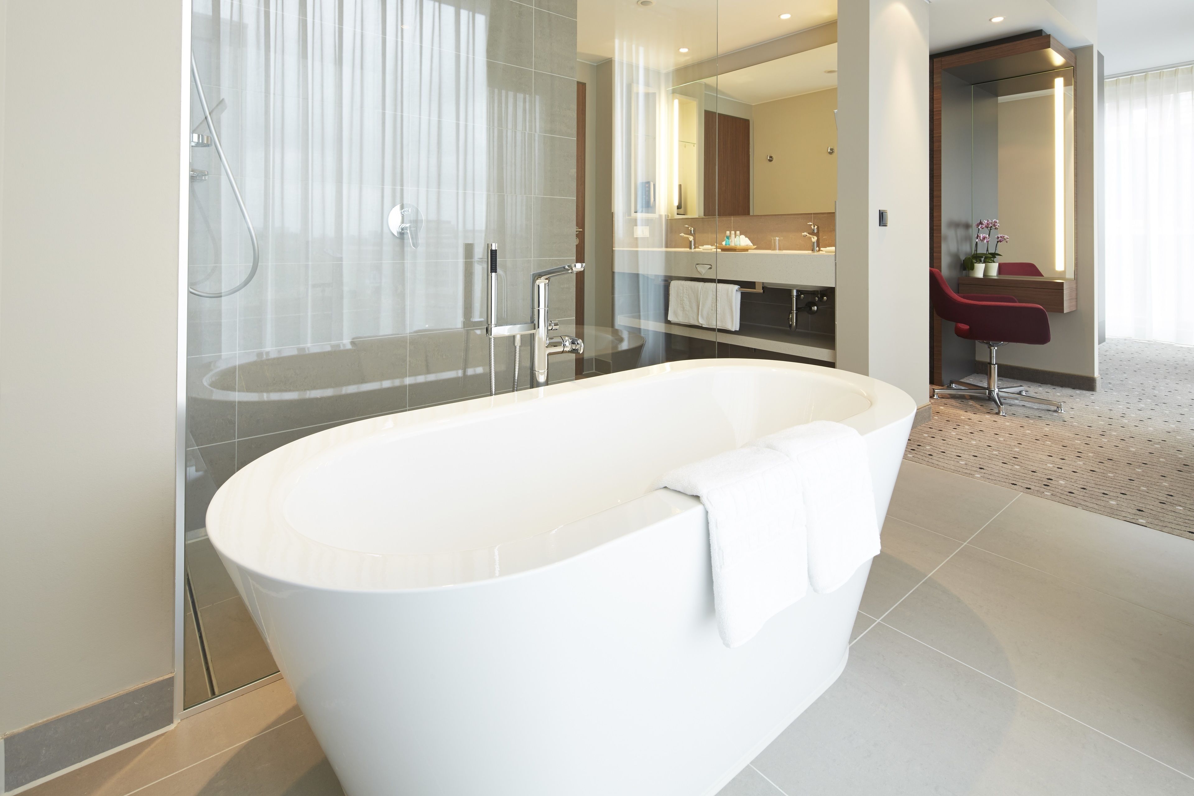 A modern bathroom with a freestanding bathtub, a glass-enclosed shower, and a vanity with a mirror.