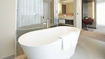 A modern bathroom with a freestanding bathtub, a glass-enclosed shower, and a vanity with a mirror.