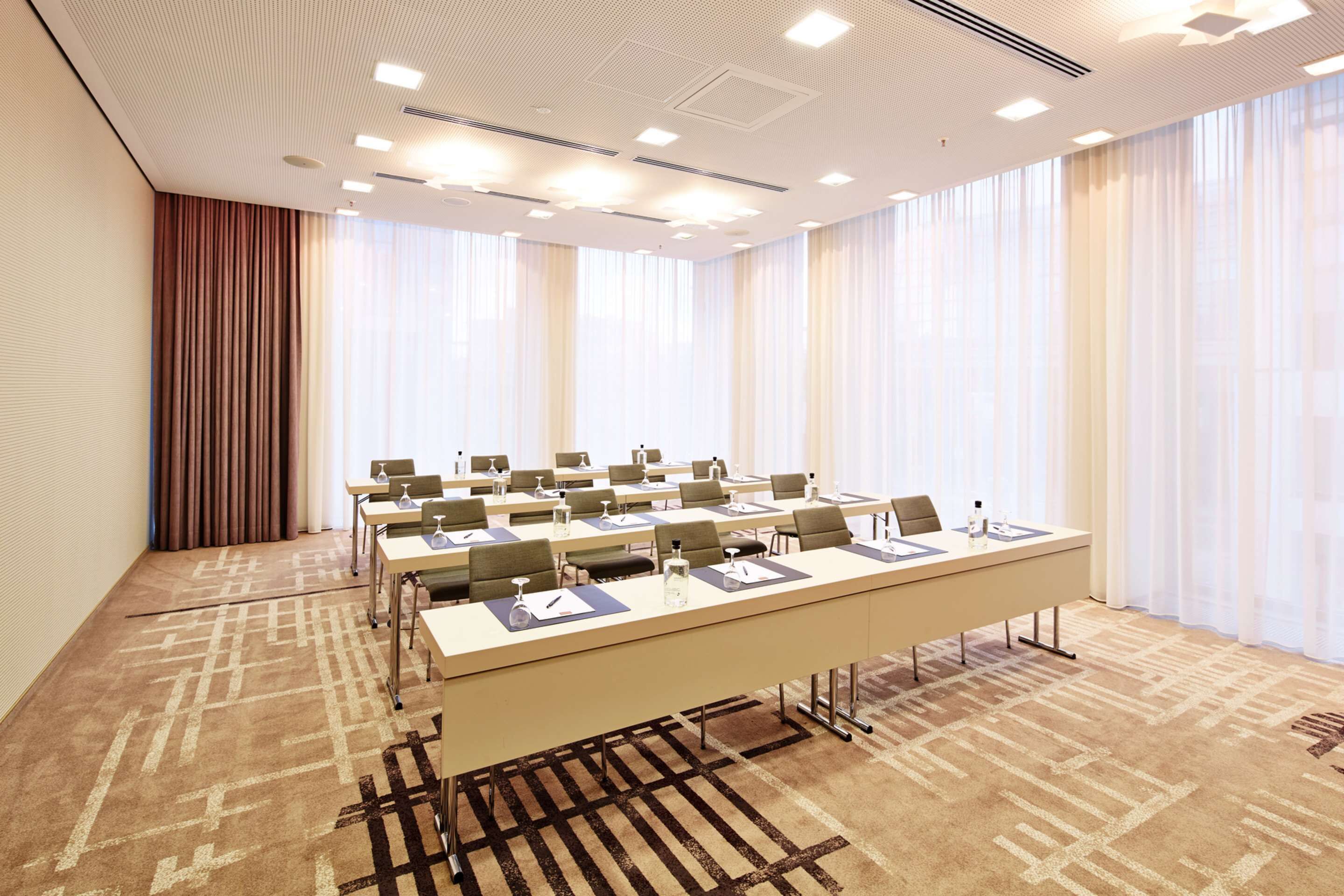 A conference room with a long table, chairs, and a carpeted floor.