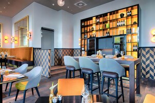 Ein Restaurant mit Barbereich, Sitzgelegenheiten und einer Weinauslage.