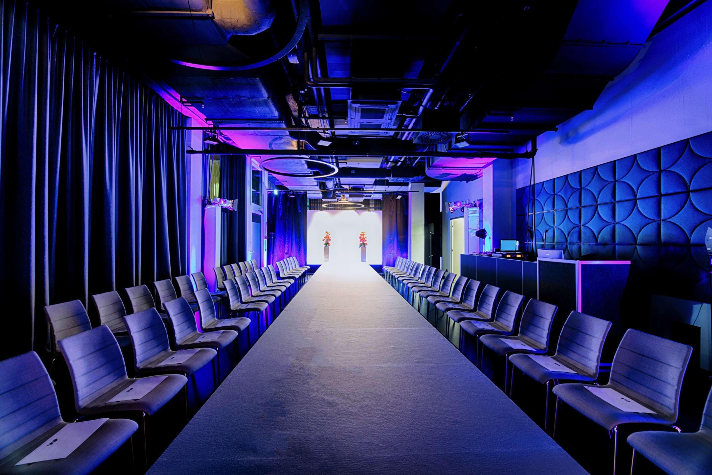 A conference room with rows of chairs facing a stage.