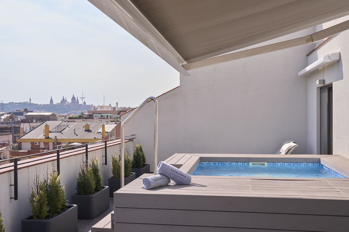 Eine Dachterrasse mit Pool, Topfpflanzen und Blick auf die Skyline der Stadt.