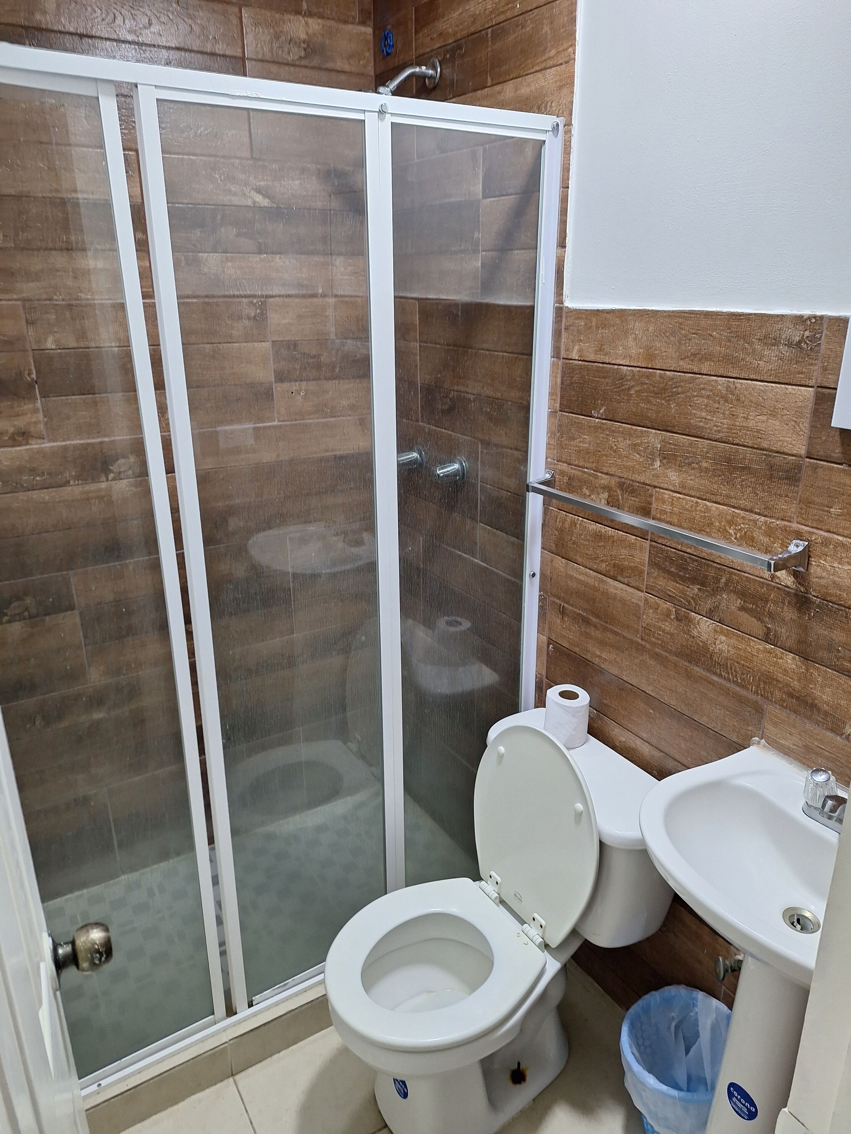 Un bagno con box doccia, water e lavandino.