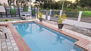 A rectangular swimming pool with blue tiles and a brick border. - Express Inn Panama International Airport Hostel (Tocumen)