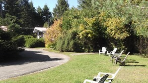 A grassy area with outdoor seating and a paved path. - Auberge Mountain View Inn (Mont-Tremblant)