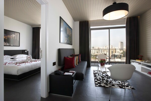 Relax in a stylish room with a large bed, black sofa, and city view.