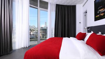 Een hotelkamer met een groot bed, uitzicht op de stad en een modern design.