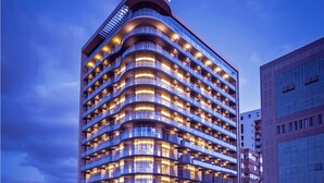 A modern hotel with multiple balconies and a curved facade. - The Smallville Hotel (Beirut)