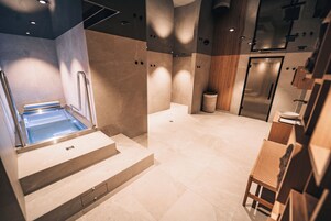 Un baño moderno con bañera integrada, tocador de madera y una zona de estar.