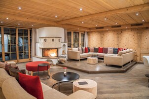 Un amplio salón con chimenea, sofás y una mesa de centro.