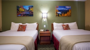 A hotel room with two beds, a nightstand, a wall-mounted lamp, and two landscape paintings. - Red River Inn Silt-Rifle (Silt)