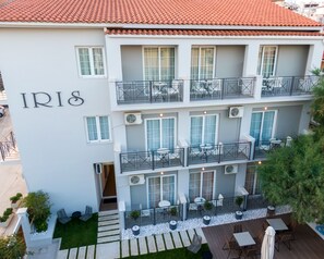 A multi-story hotel with balconies, outdoor seating, and a rooftop terrace. - Iris Skiathos (Skiathos)