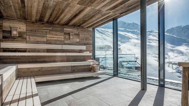 Un interior moderno con paneles de madera y un amplio ventanal que ofrece vistas a la montaña.