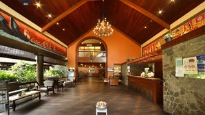 A spacious lobby with wooden beams, a chandelier, and a reception desk. - Uday Suites (Thiruvananthapuram)