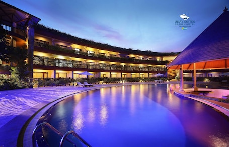 Una piscina al aire libre, sombrillas, sillones reclinables de piscina