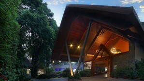 A modern building with a sloped roof and a large entrance. - Uday Suites (Thiruvananthapuram)