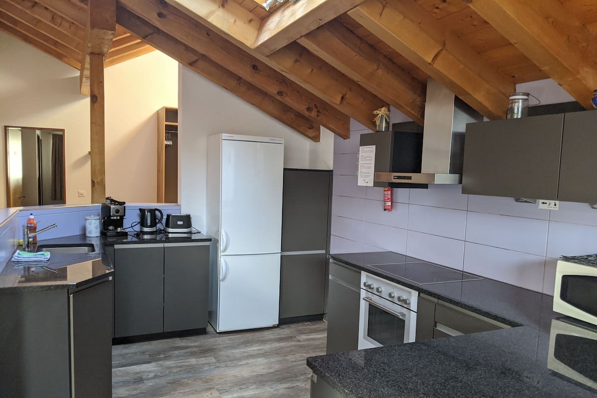A modern kitchen with a built-in refrigerator, stove, and microwave.