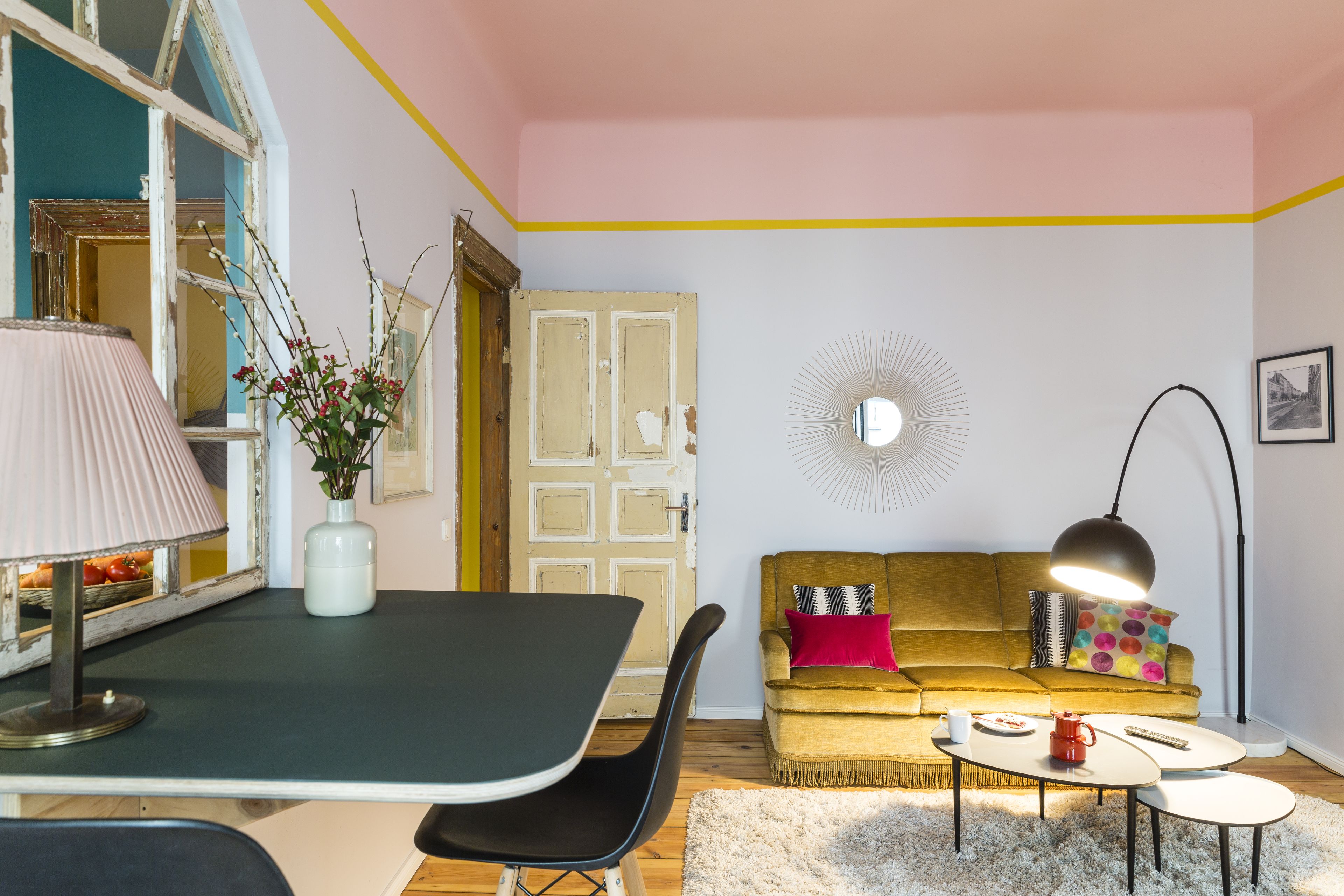Un salon chaleureux avec une table à manger, un canapé et une lampe.
