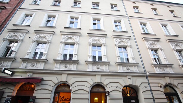 A multi-story building with arched windows and a classic architectural style. - Rainbow Apartments 2 (Kraków)
