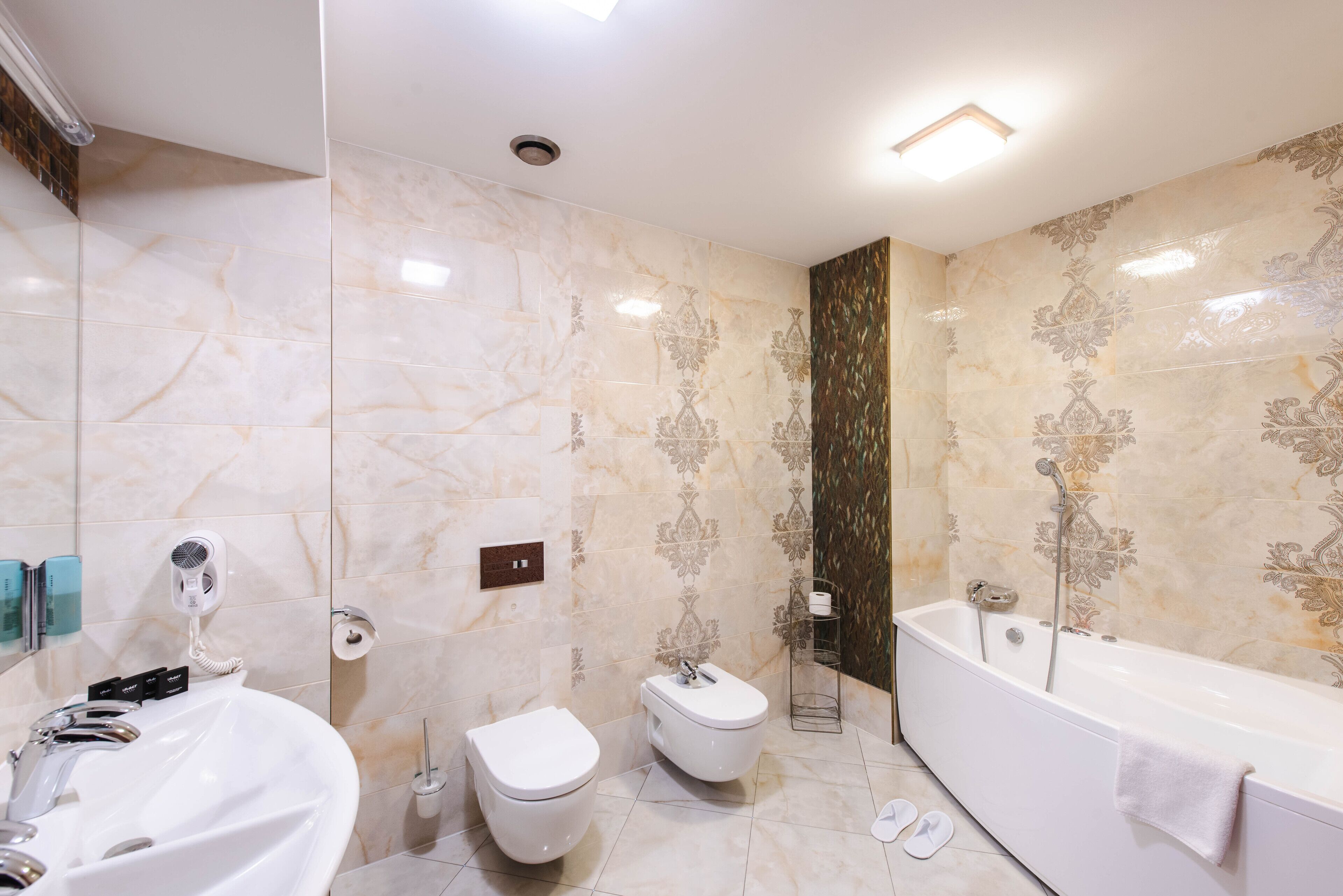 A modern bathroom with a large bathtub, a sink, and a toilet.